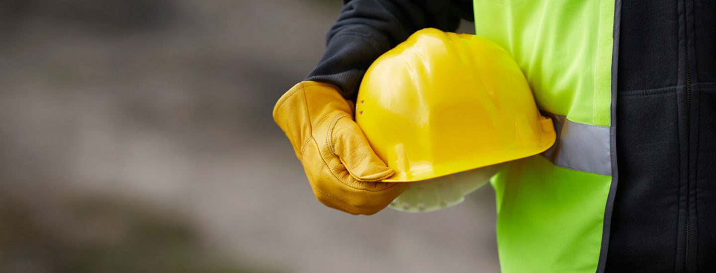 Zoomed image of man carrying yellow hard hat