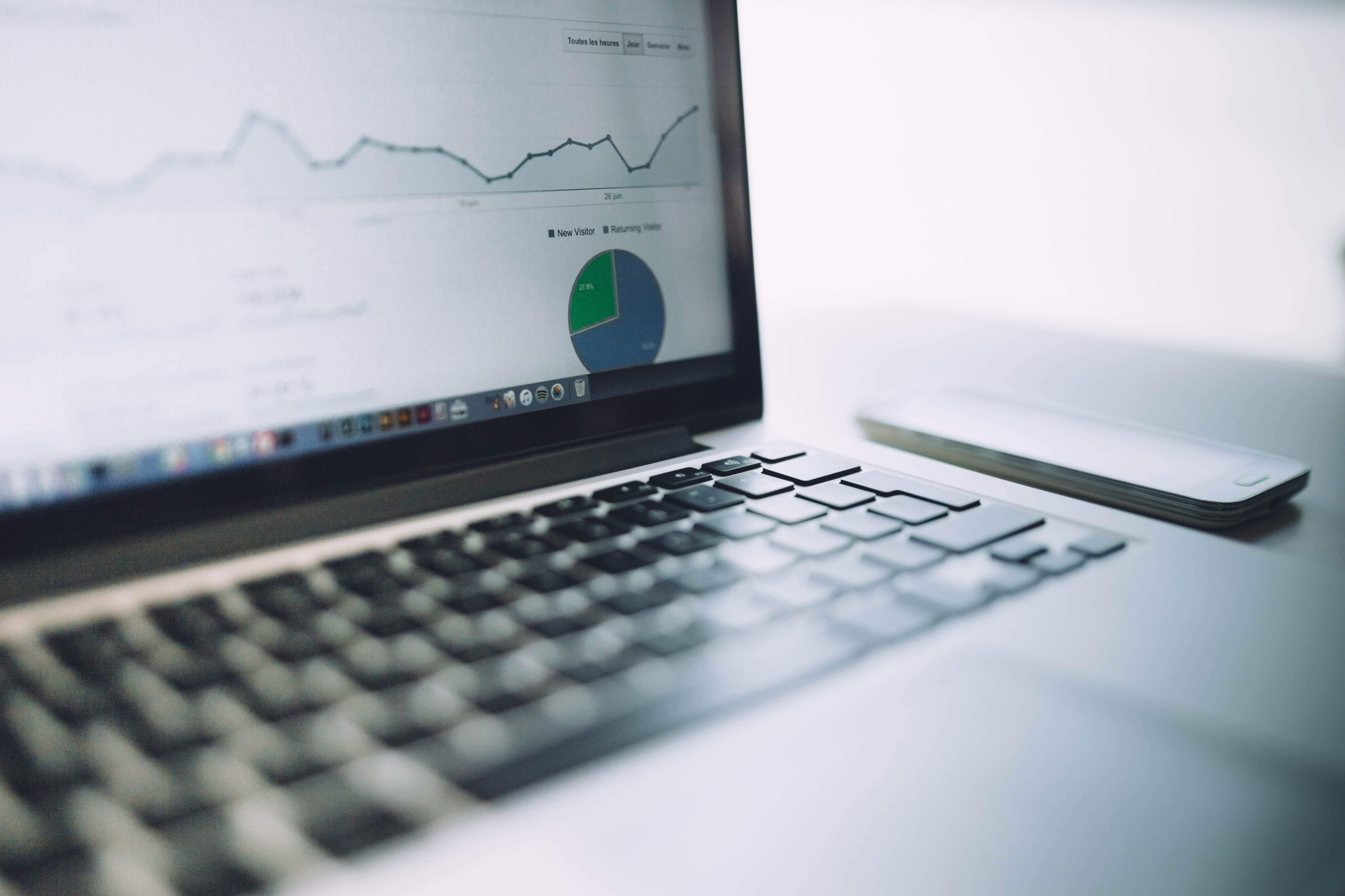 Close up photograph of laptop with data graphs on the screen